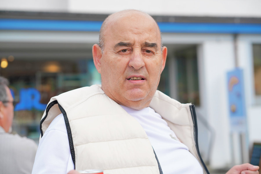 Close-up of a man wearing a light-coloured quilted gilet against a blurred background.